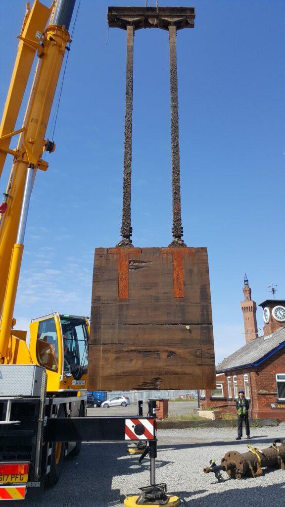 Large wooden crate being held up by a crane lift